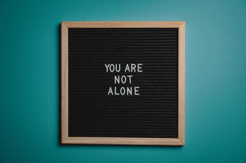 Board that says "You Are Not Alone"