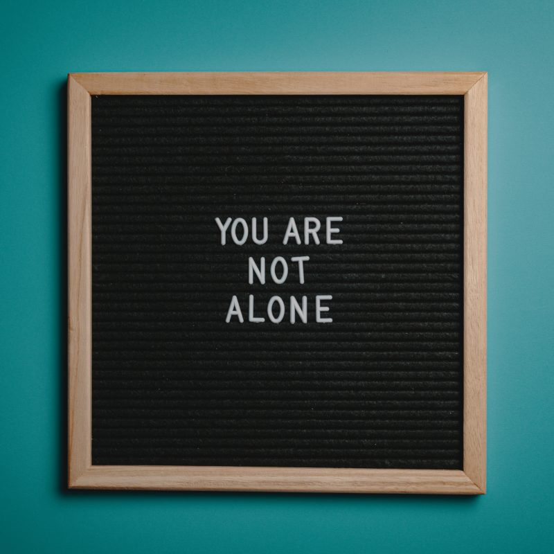 Board that says "You Are Not Alone"